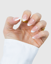 A hand wearing Loste false nails in a classic French design and in an almond shape