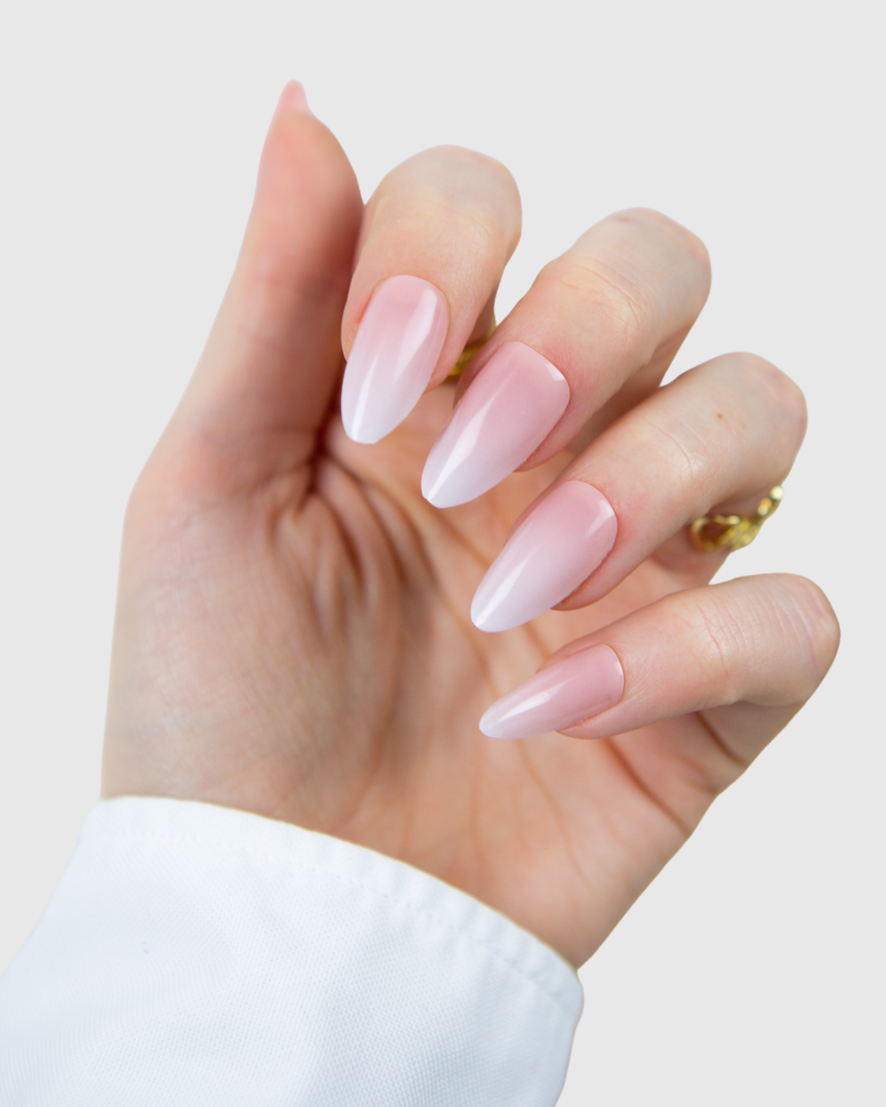 A close-up of a hand with long, almond-shaped Loste press-on nails